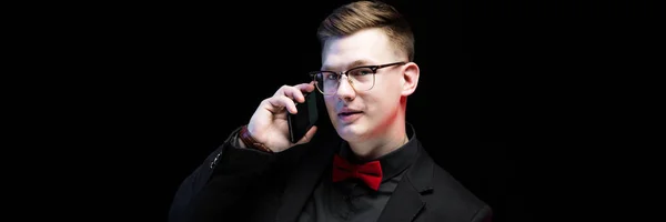 Portret van vertrouwen knappe ambitieuze gelukkig elegante verantwoordelijk zakenman praten over telefoon op zwarte achtergrond — Stockfoto