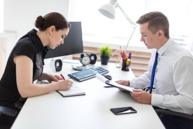 Gençler bilgisayar tablo ve belgelerle çalışma ofisinde oturup.