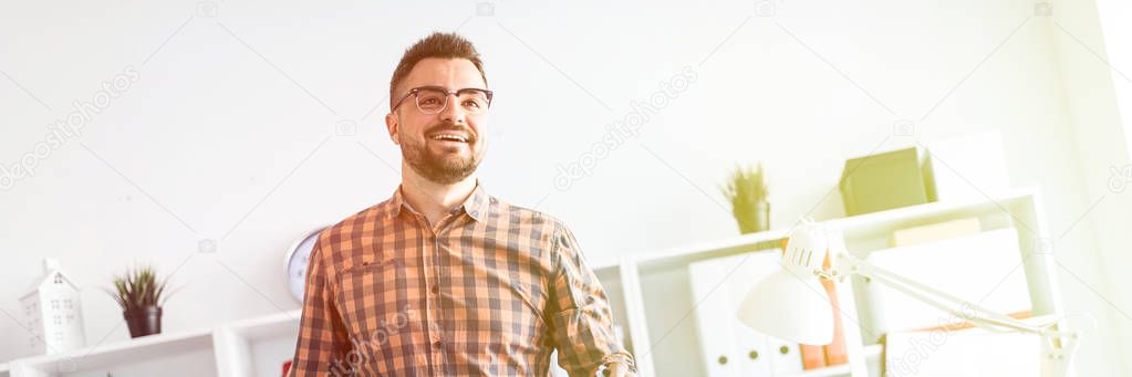 The man in the office is standing near the table and explains the schedule drawn on the magnetic board.