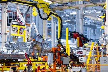 robot kolu araba detayını tutar. Araba üretim tesisi