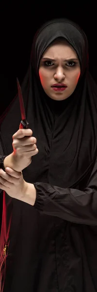 必死の美しい肖像画を怖がって黒い背景に保護概念として手にナイフを持った黒いヒジャーブを着ておびえた若いイスラム教徒の女性 — ストック写真