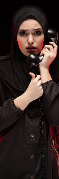 Porträt einer schönen, verängstigten jungen Muslimin, die einen schwarzen Hijab trägt und auf schwarzem Hintergrund um Hilfe ruft — Stockfoto