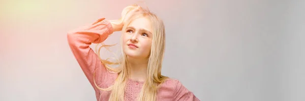 Hermosa chica adolescente con el pelo largo blanco. Un adolescente se para y sostiene su cabello con su mano — Foto de Stock