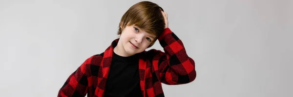 Cute sweet smiling little caucasian boy in checkered shirt on grey background — Stock Photo, Image