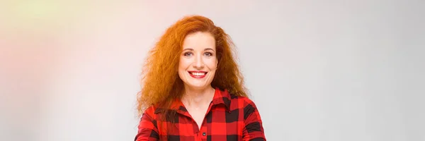 Menina ruiva jovem em uma camisa quadriculada vermelha. Jovem menina abriu os braços — Fotografia de Stock