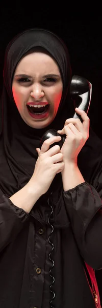 Πορτρέτο του όμορφη σοβαρή φοβισμένη νεαρή μουσουλμάνα φορώντας μαύρο χιτζάμπ ουρλιάζοντας κλήση για βοήθεια σε μαύρο φόντο — Φωτογραφία Αρχείου