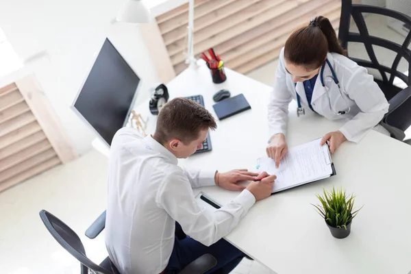 Il ragazzo dello studio medico firma i documenti. . — Foto Stock