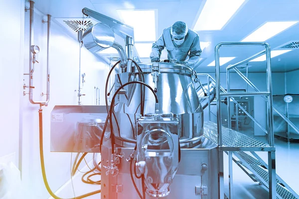 Wetenschapper kijk in stalen tank in laboratorium. Blauwe Toon. Blauwe tint — Stockfoto