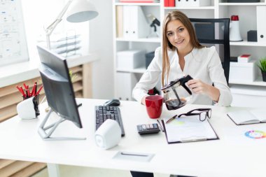 Bilgisayarda ofis masasında oturan genç bir kız ve onun kahve dökülen.