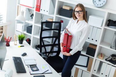 Genç bir kız bir bilgisayar Danışma standları ve belgeler ile bir klasör tutar