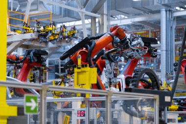 robot kolu araba detayını tutar. Araba üretim tesisi