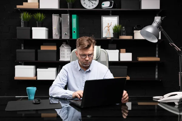 Serious businessman working on laptop and drinking coffee — Stock Photo, Image