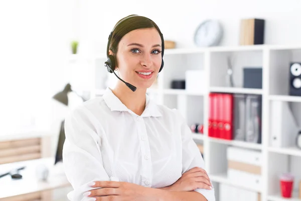 Una joven con auriculares y micrófono está en una oficina luminosa. . — Foto de Stock