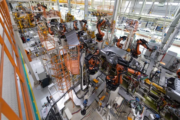 Carrocería del coche en vista superior del transportador. Ensamblaje moderno de coches en la planta. El proceso de construcción automatizado de la carrocería —  Fotos de Stock