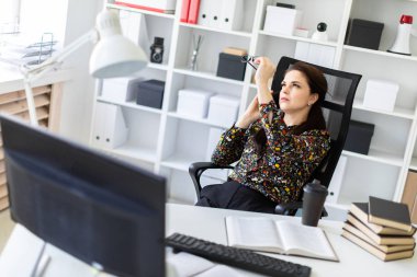 Bilgisayar Resepsiyon ofiste oturan ve telefonda konuşurken bir genç kız.
