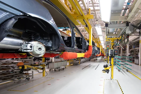 Transfert de la carrosserie vue du bas. L'équipement robotique fait l'assemblage de la voiture. Assemblage de voiture moderne à l'usine — Photo