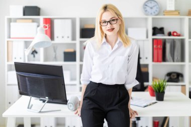 Genç bir kız ofiste masanın üstüne eğildi.