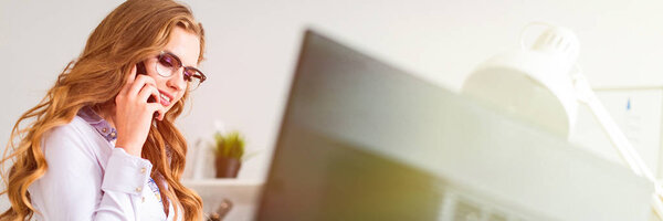 Красивая молодая девушка села на стол в офисе и разговаривала по телефону. Перед девушкой есть документы.
.