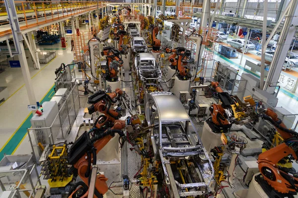 Carrocería del coche en vista superior del transportador. Ensamblaje moderno de coches en la planta. El proceso de construcción automatizado de la carrocería —  Fotos de Stock