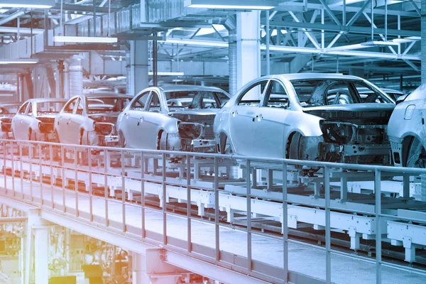 Karosserien laufen am Fließband. Fabrik für die Produktion von Autos in blau. moderne Automobilindustrie. Blauton — Stockfoto