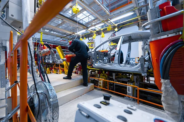 Engenheiro montar o carro na linha de produção. Fábrica de automóveis — Fotografia de Stock