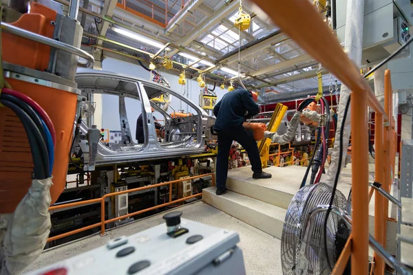 Os trabalhadores montam uma carroçaria. processo de soldagem de carros. Montagem moderna de carros na fábrica. processo de construção automatizado da carroçaria do carro — Fotografia de Stock