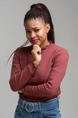 Beyaz arka plan üzerinde izole güzel siyah kadın ayakta tutma çene dikey portresi