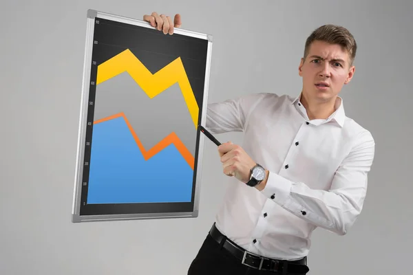 Young man holding a magnetic Board with a graph isolated on a light background — Stock Photo, Image