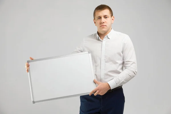 Empreendedor com uma placa magnética em suas mãos sobre fundo branco — Fotografia de Stock