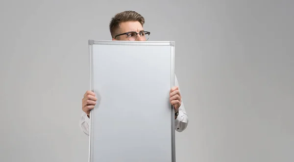 Parte do jovem vestindo óculos com placa magnética limpa em suas mãos isolado no fundo branco — Fotografia de Stock