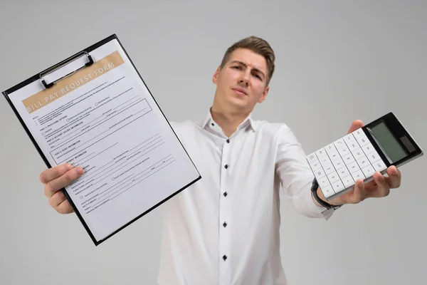 Porträt eines jungen Mannes mit Rechnungen und Taschenrechner in der Hand isoliert auf weißem Hintergrund — Stockfoto