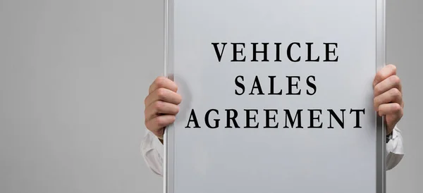 Männliche Hände halten ein Plakat mit der Aufschrift Fahrzeugkaufvertrag isoliert auf hellem Hintergrund — Stockfoto