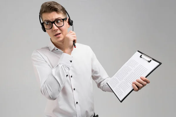 Jovem em óculos e fones de ouvido com seguro em mãos isoladas em fundo branco — Fotografia de Stock