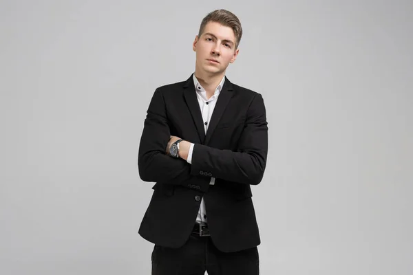 Portrait of young man in black suit with arms crossed isolated on white background — Stock Photo, Image