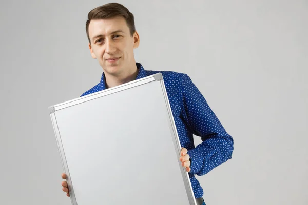 Empreendedor com uma placa magnética em suas mãos sobre fundo branco — Fotografia de Stock