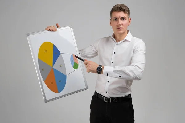 Young man holding a poster with a diagram isolated on a light background — Stock Photo, Image