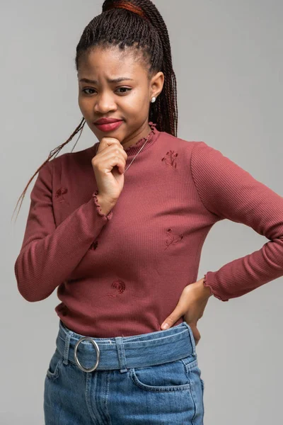 Beyaz arka plan üzerinde izole güzel siyah kadın ayakta tutma çene dikey portresi