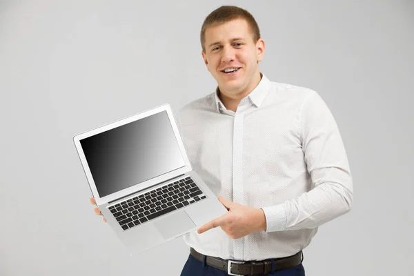그의 손에 빈 화면 노트북으로 젊은 남자 밝은 배경에 고립 — 스톡 사진