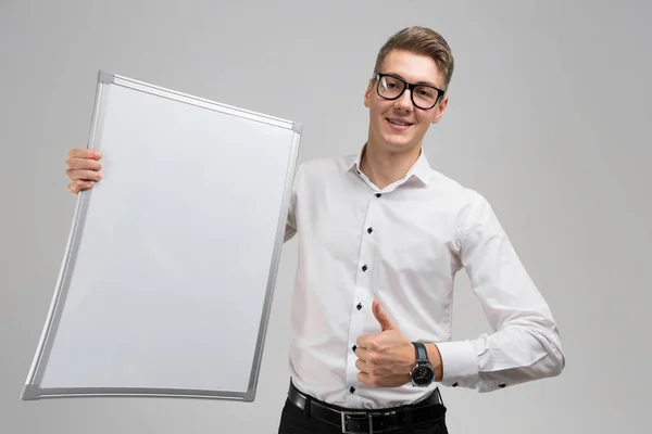 Porträt eines überraschten jungen Mannes in Brille mit sauberem Brett und zeigt Zeichen super isoliert auf weißem Hintergrund — Stockfoto