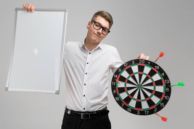 hedef ile gözlüklü genç adamla değil Merkezi, dart ve beyaz arka plan üzerinde izole onun elinde boş levha