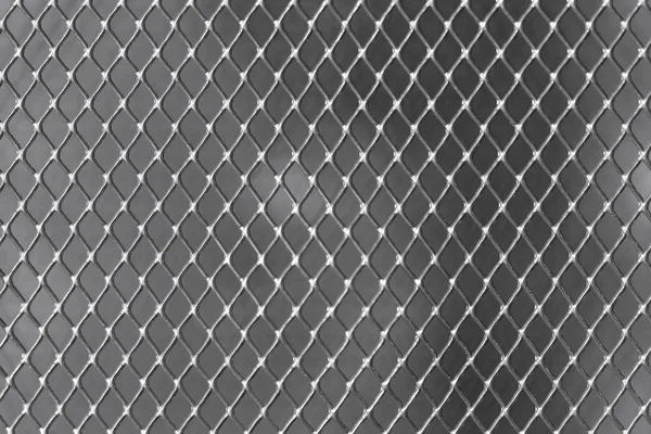 Plasă metalică strălucitoare fundal întunecat close-up — Fotografie, imagine de stoc