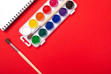 Suluboya boya ve fırça ile tuval boyama ile kırmızı zemin üzerine boşaltmak için