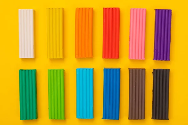 Набор разноцветного пластилина изолирован на желтом фоне — стоковое фото