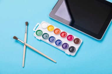 Suluboya boya ve fırça ile mavi arka plan tablete