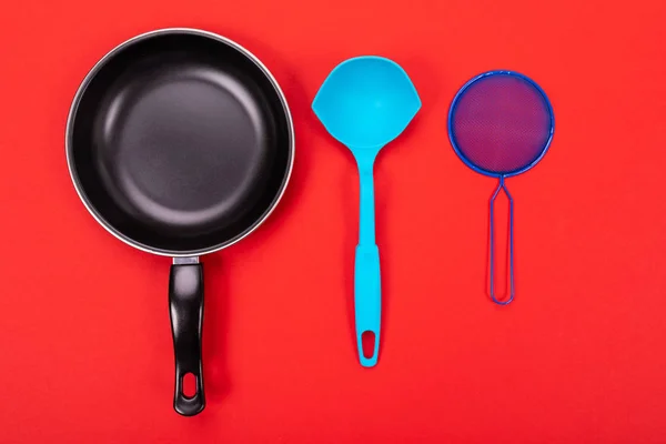 Kookgerei in keuken geïsoleerd op rode achtergrond met copyspace — Stockfoto