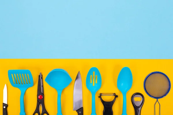Ontwerpconcept van keukengerei geïsoleerd met copyspace op de blauw-gele achtergrond — Stockfoto