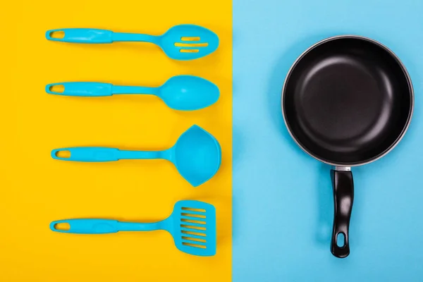 Imagen de cerca de sartén con espátula y cuchara como utensilios de cocina para el concepto de cocina —  Fotos de Stock