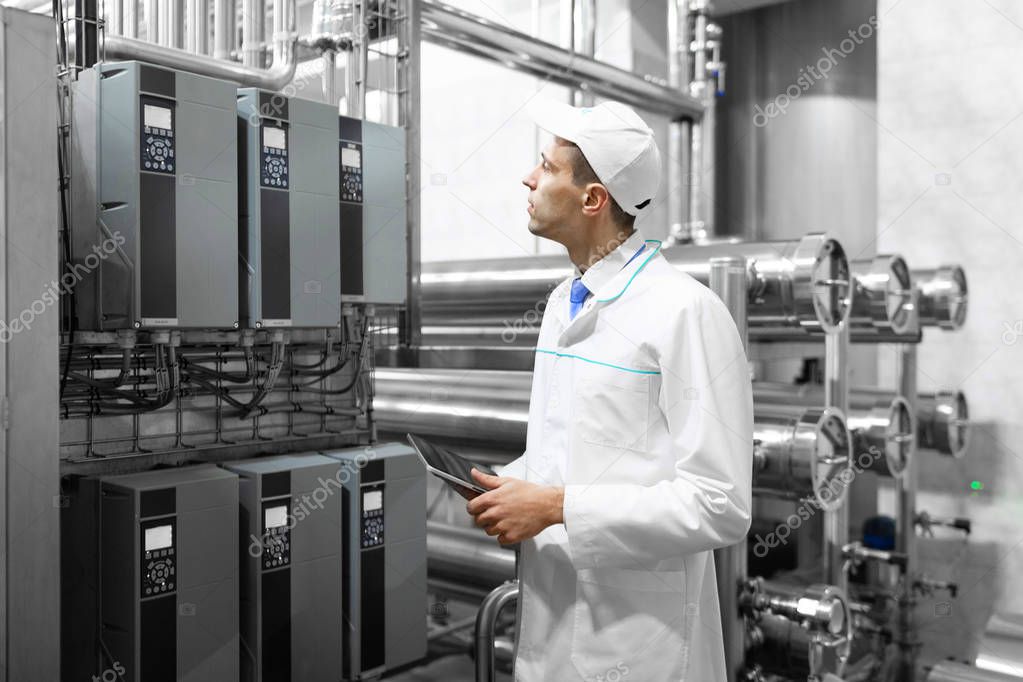 Technologist with a tablet in his hands at the dairy plant