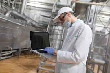 Bir laptop süt fabrikasında onun elinde olan bir çalışan