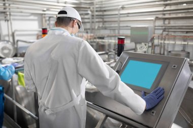 Süt fabrikasında üretim bölümü dururken gerekli notlar alarak teknoloji uzmanı
